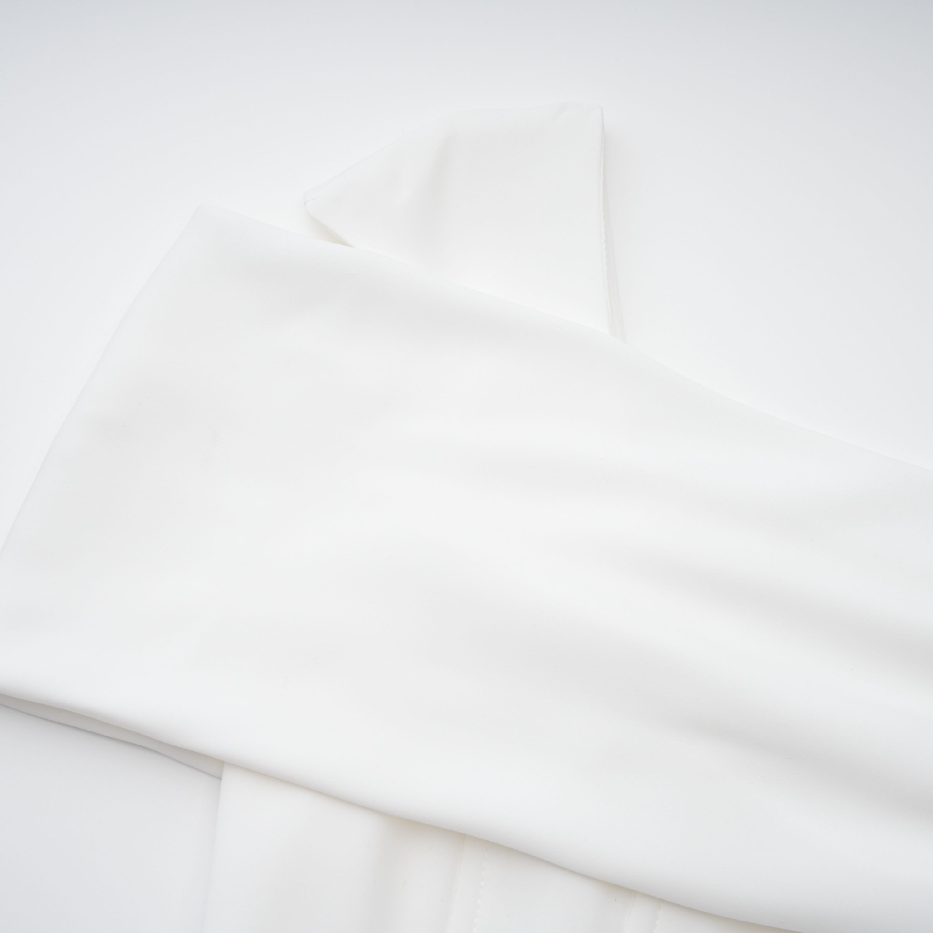 Vestido midi blanco Brideal Solara con drapeado y estilo elegante, mostrado en una imagen con fondo neutro