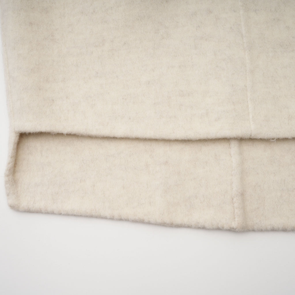 Abrigo blanco con cinturón de Bridal, con detalles de pelaje en el dobladillo y cuello, elegante y de corte clásico.