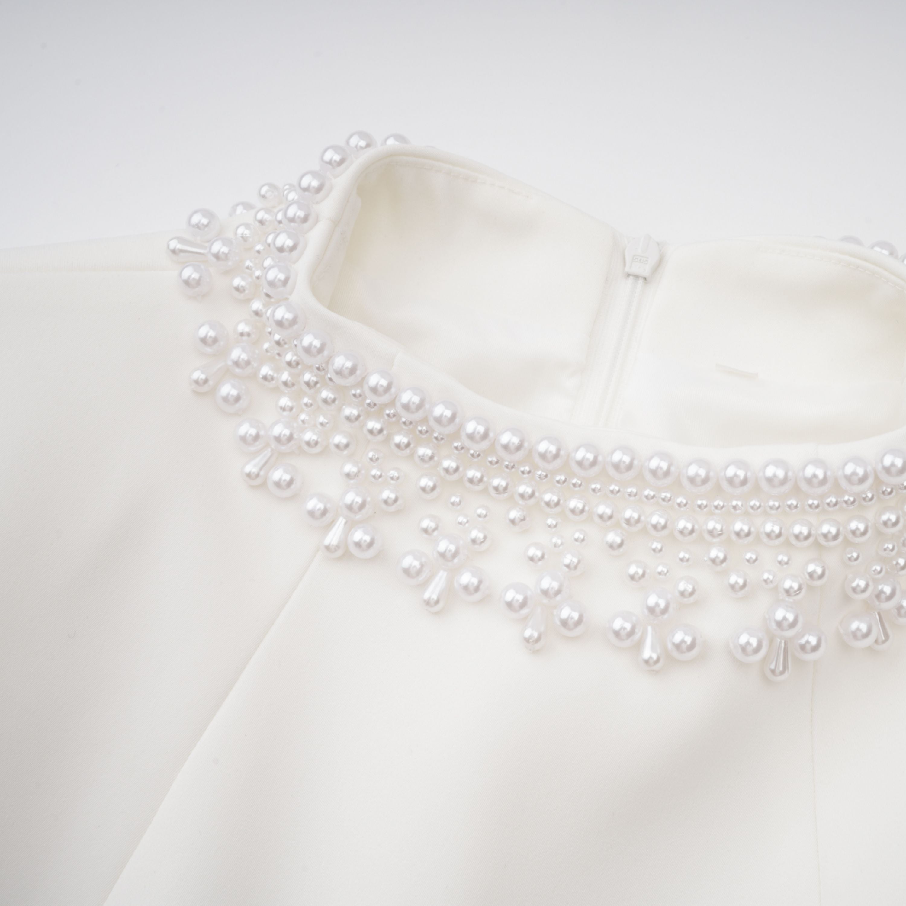 Vestido mini blanco con perlas falsas y escote en V, diseñado por Final Sale, para ocasiones elegantes y sofisticadas.