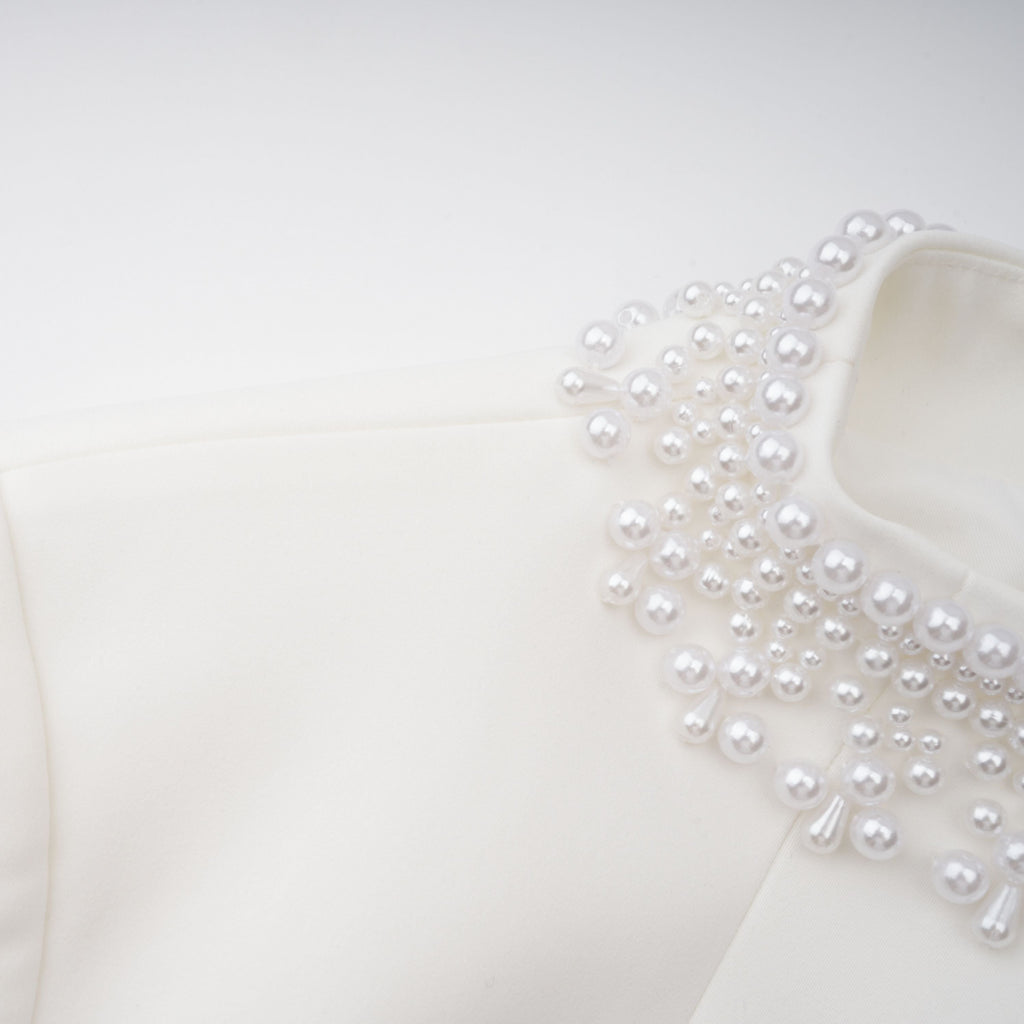 Vestido mini blanco con perlas falsas, estilo elegante de la marca Final Sale, con detalles en el escote y falda ajustada.