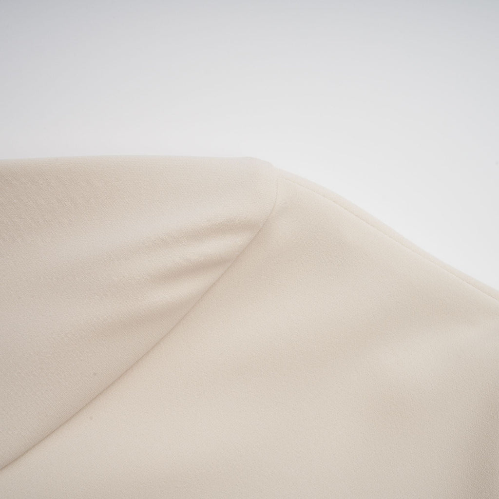 Vestido mini ajustado en color crema de Chloé, con diseño elegante y detalles sofisticados, en un fondo neutro.