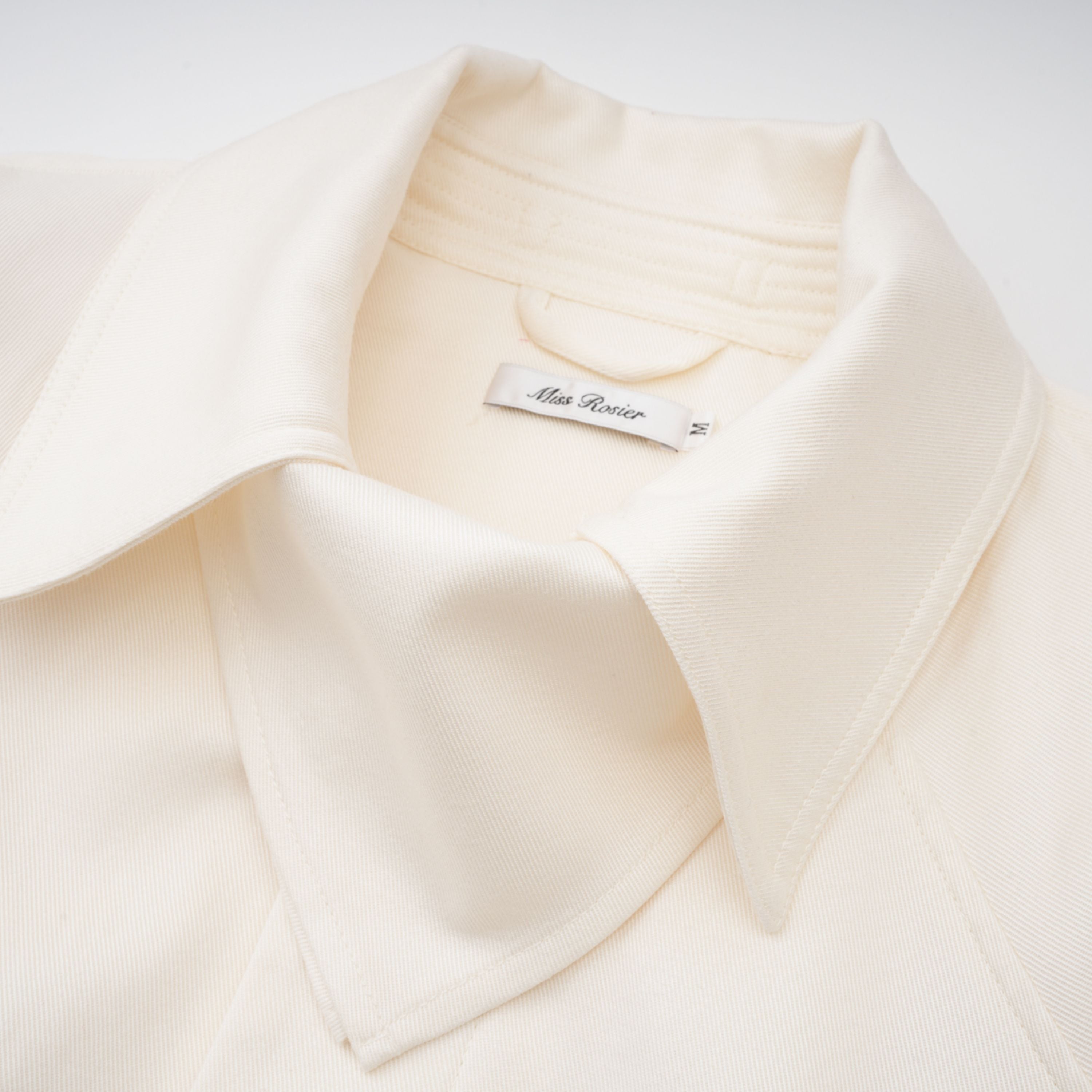 Abrigo trench blanco con cinturón de la marca Final Sale, modelo Ambre Cream, mostrando el diseño elegante y detalles en la imagen