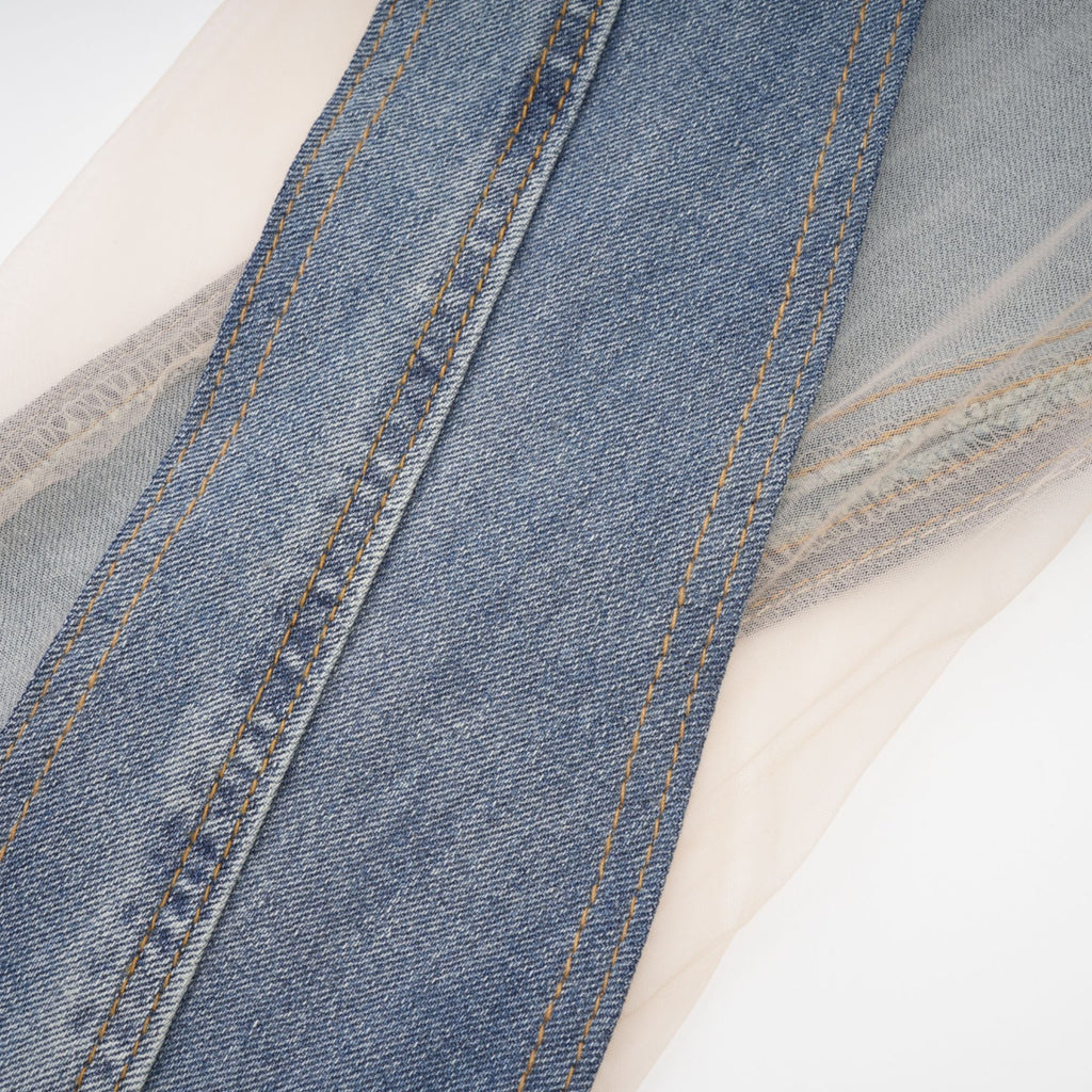 Jeans transparentes Aélis con paneles de tela ligera y diseño ajustado, en color clásico, en una modelo.
