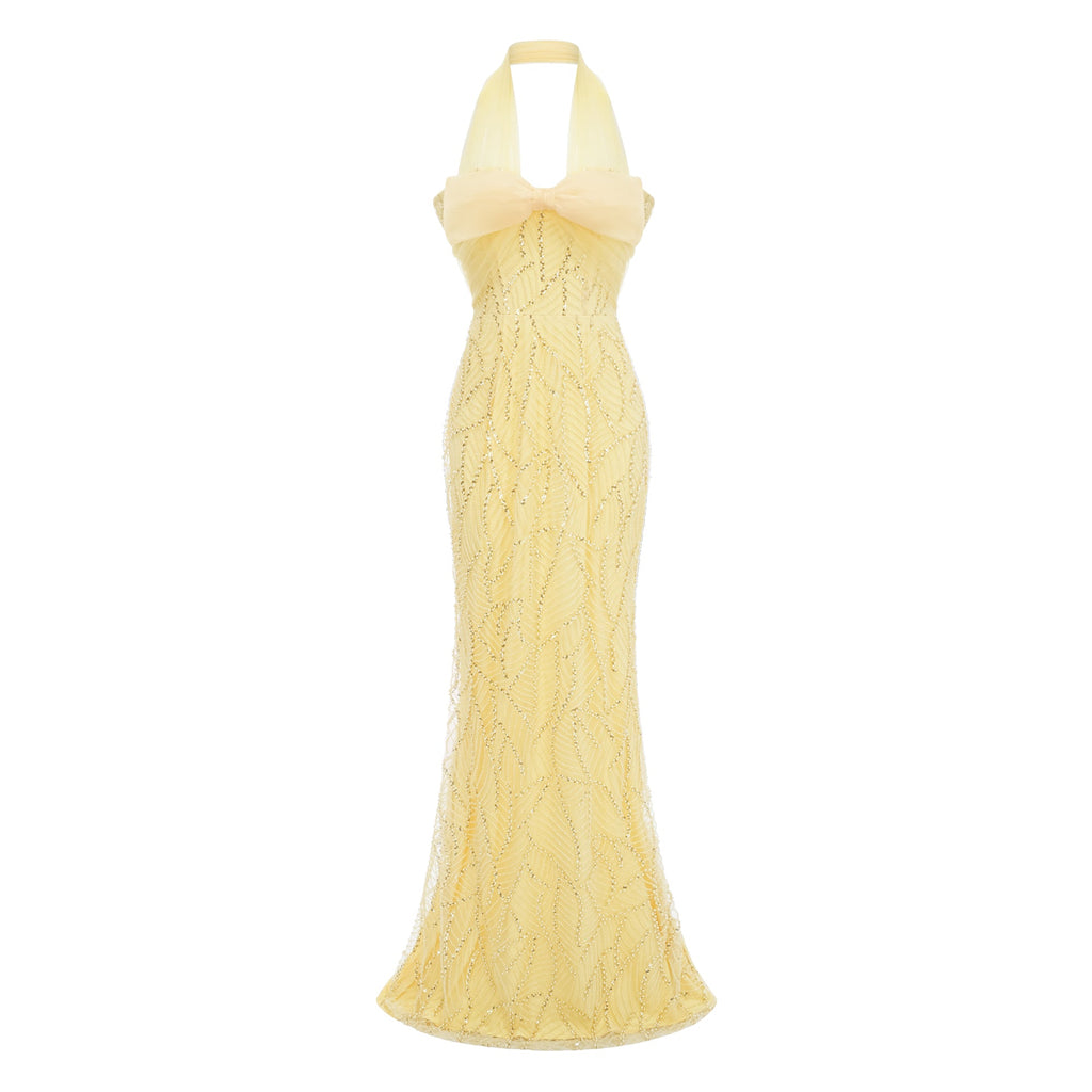 Vestido maxi amarillo Antonia de tirantes con lazo de MRNewyork, con falda larga y estilo halter, en un fondo neutro.