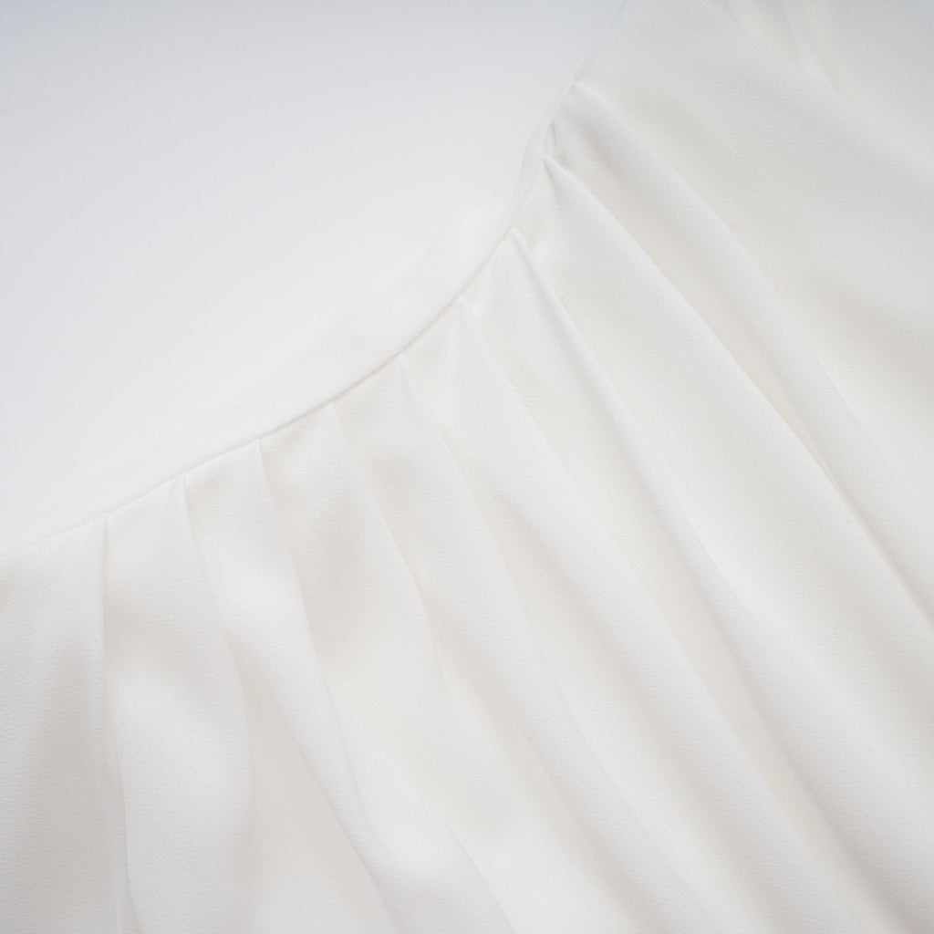 Conjunto de vestido y capa de tul blanco Léonie, para niña, con detalles delicados y elegantes, en un fondo neutro.
