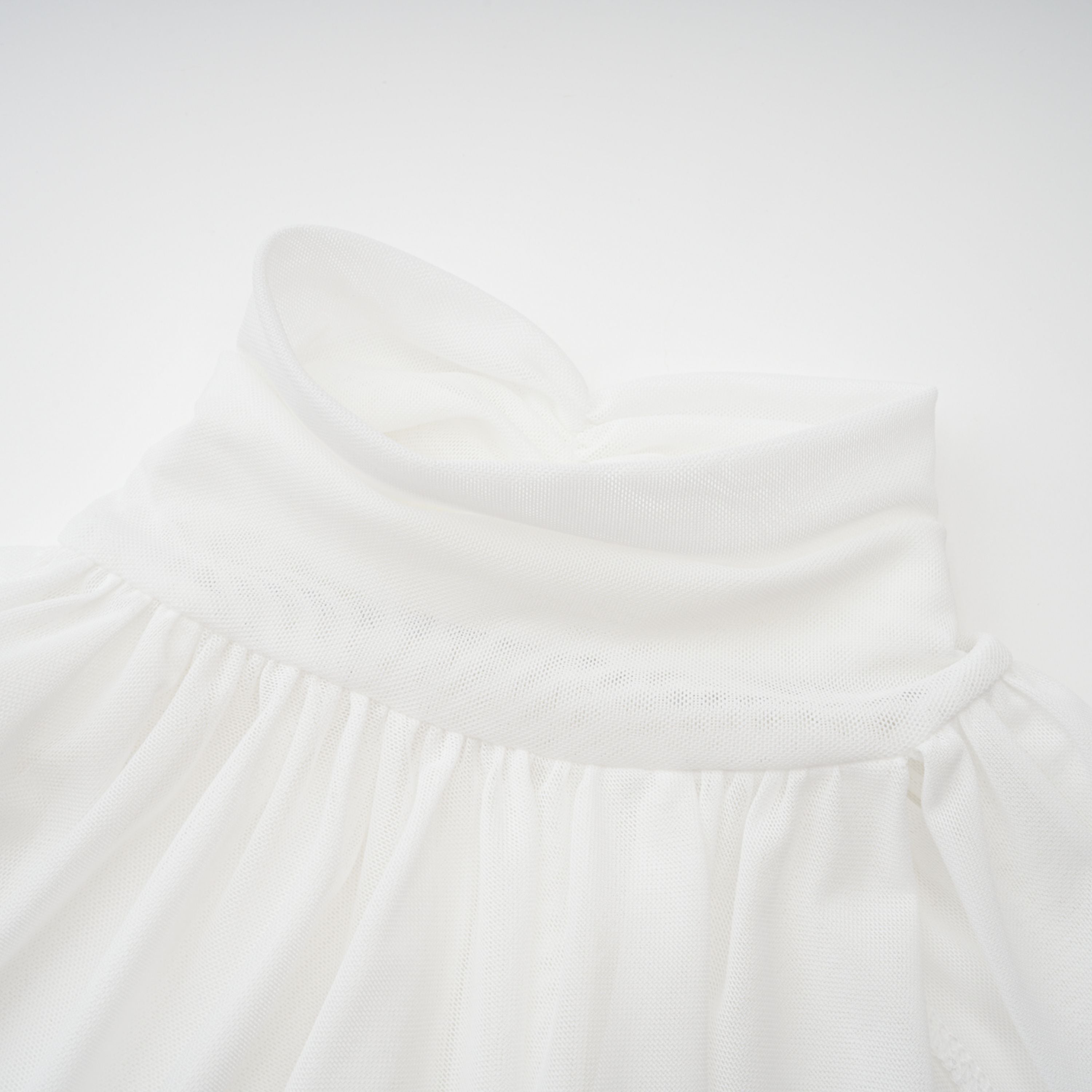 Conjunto de top y falda blanca de cuello alto y recortes de la marca Bridal, vista de la parte superior del conjunto en la imagen.