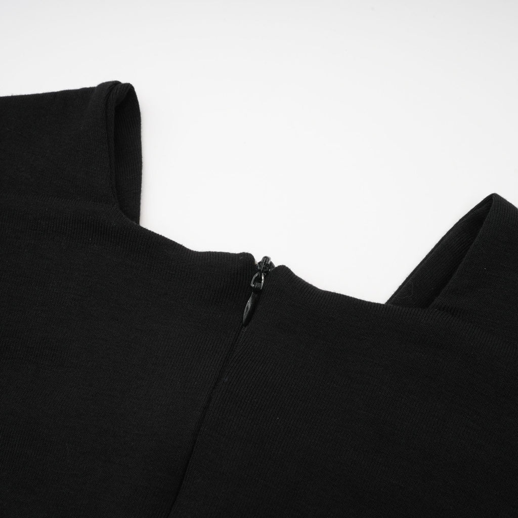 Blusa cortada con efecto fruncido y recortes en tela ligera, estilo casual y elegante, en color neutro.