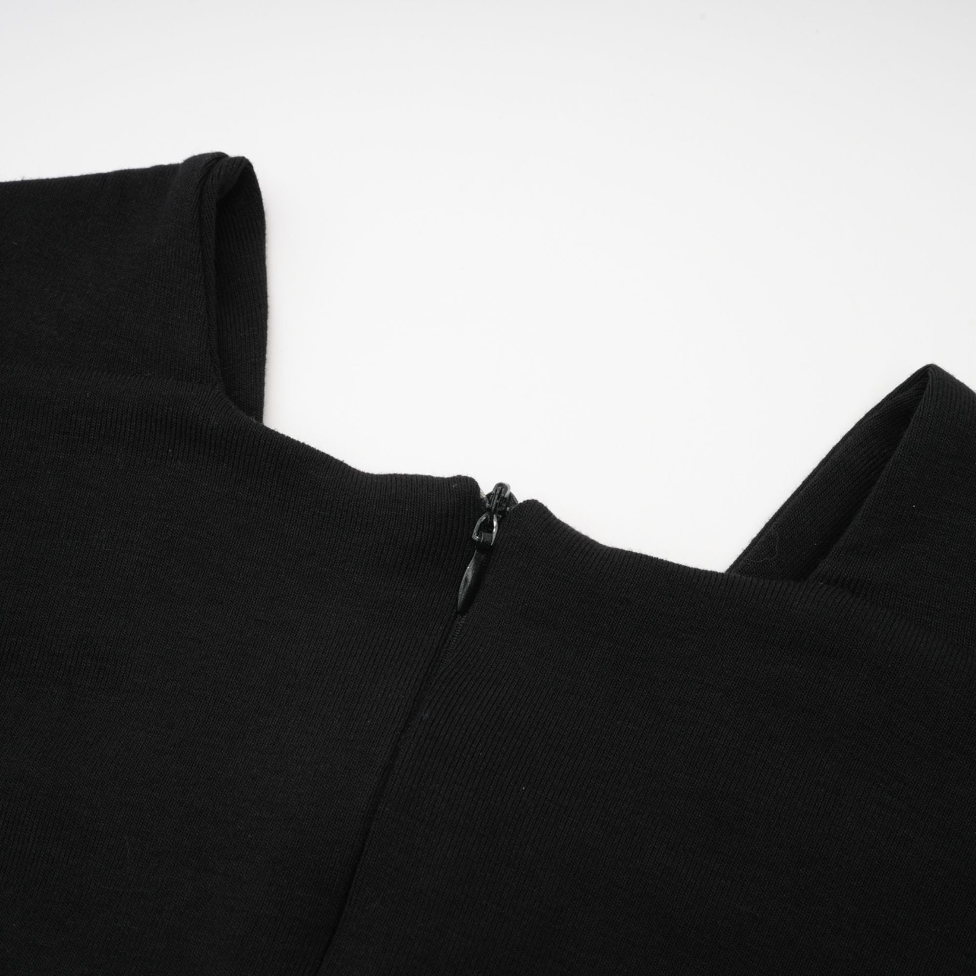 Blusa cortada con efecto fruncido y recortes en tela ligera, estilo casual y elegante, en color neutro.