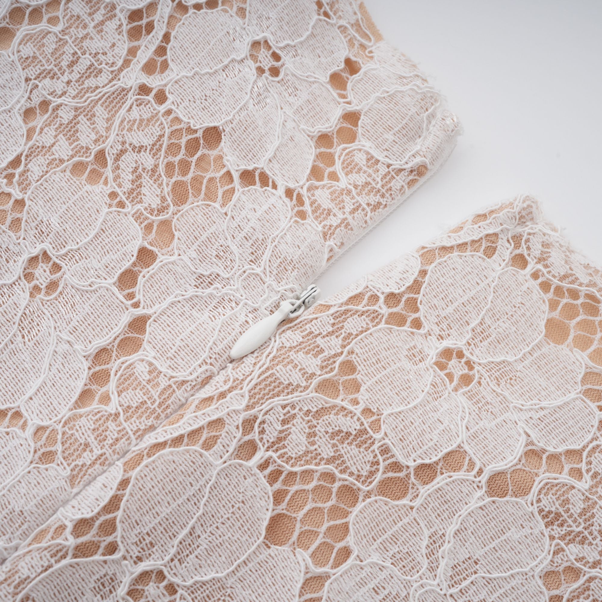 Vestido midi blanco con pliegues, detalle floral de encaje y diseño elegante, de la marca Final Sale.