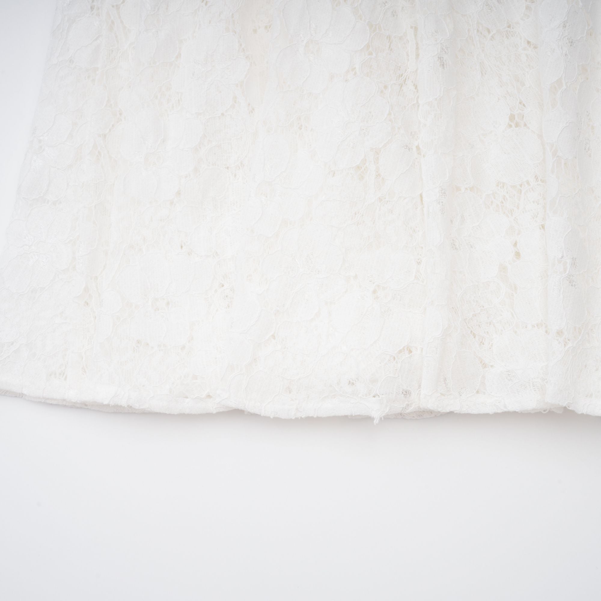 Vestido midi blanco con pliegues y encaje floral, de la marca Final Sale, mostrando detalles de la falda y parte superior.