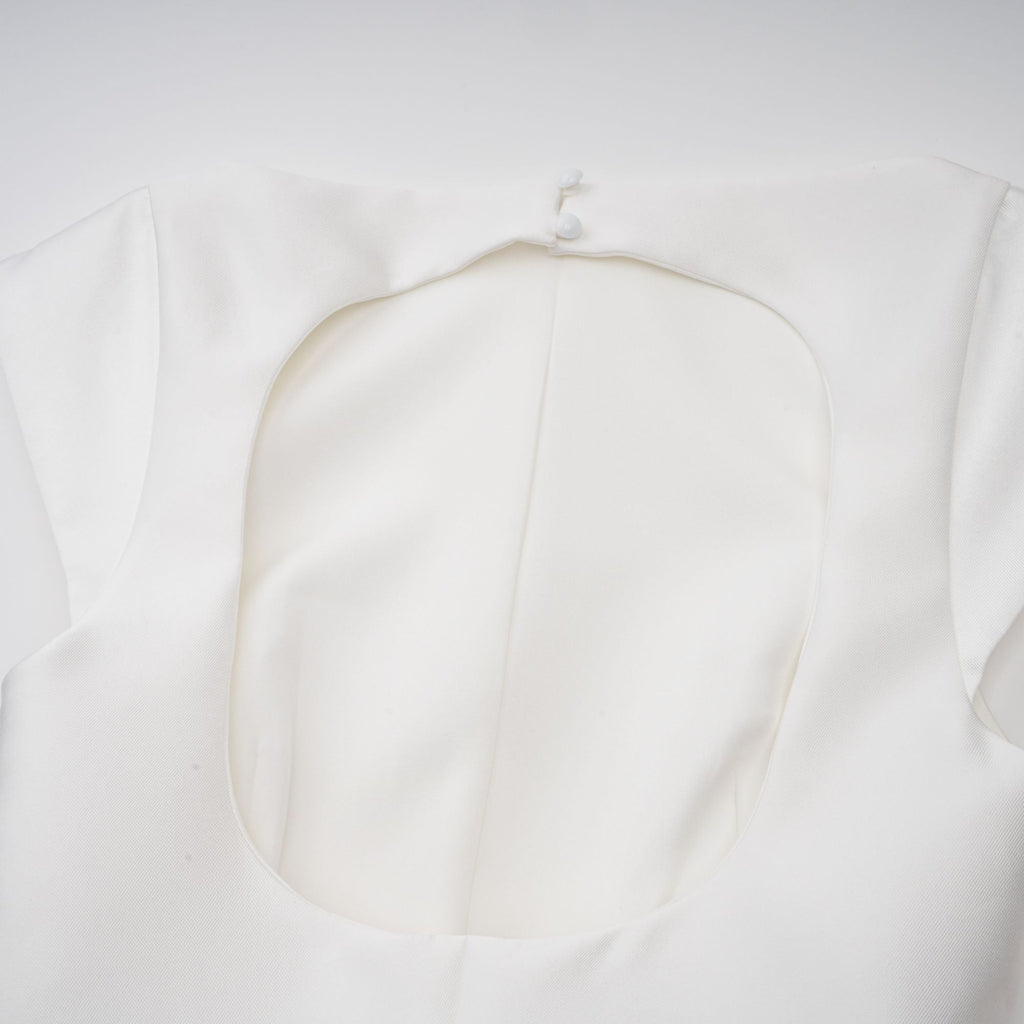 Vestido midi blanco Amandine con espalda abierta y mangas acampanadas, diseñado por Final Sale, en una modelo con fondo neutro.