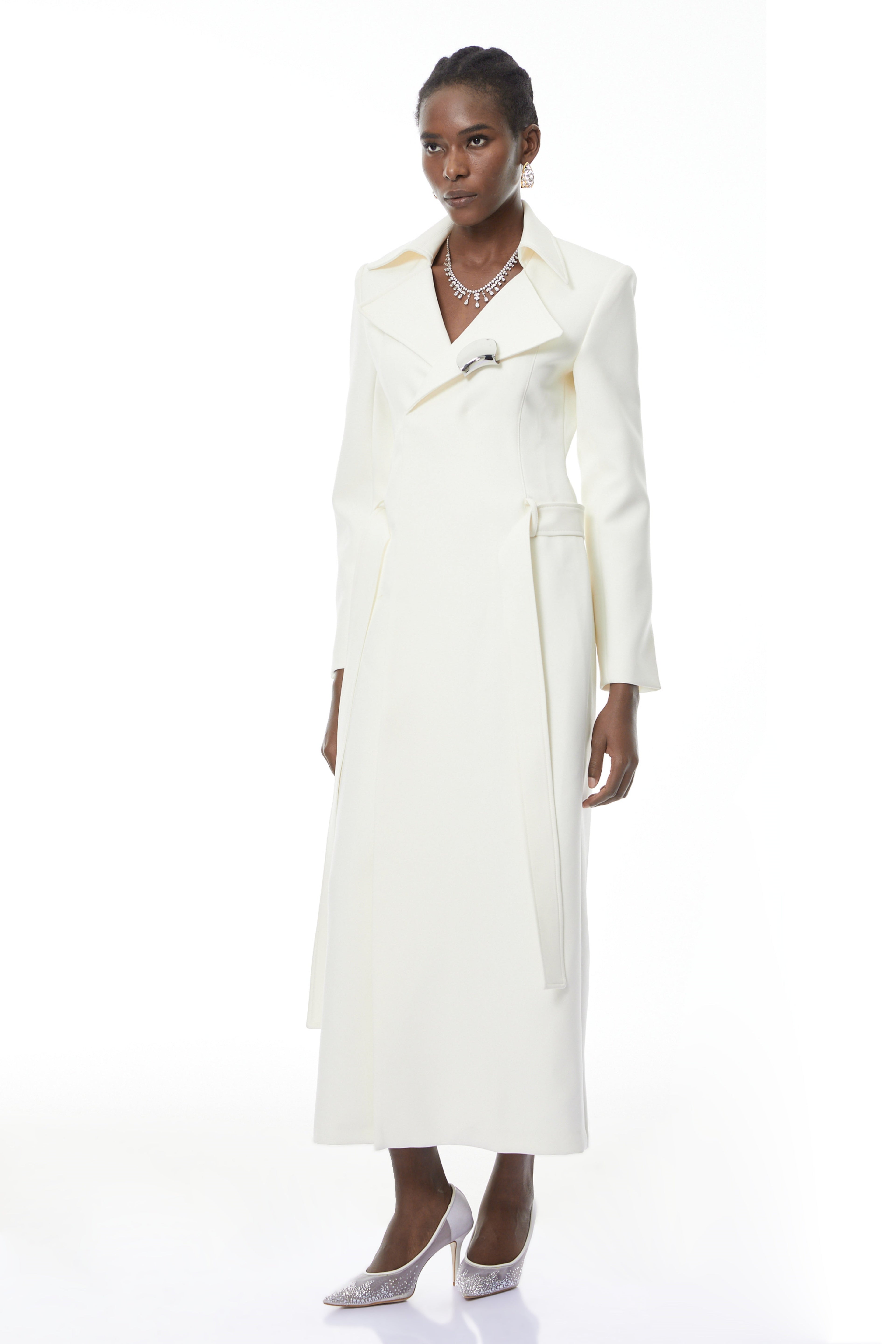 Abrigo largo con adornos en color blanco avellana de MRTokyo, con detalles decorativos y estilo elegante.