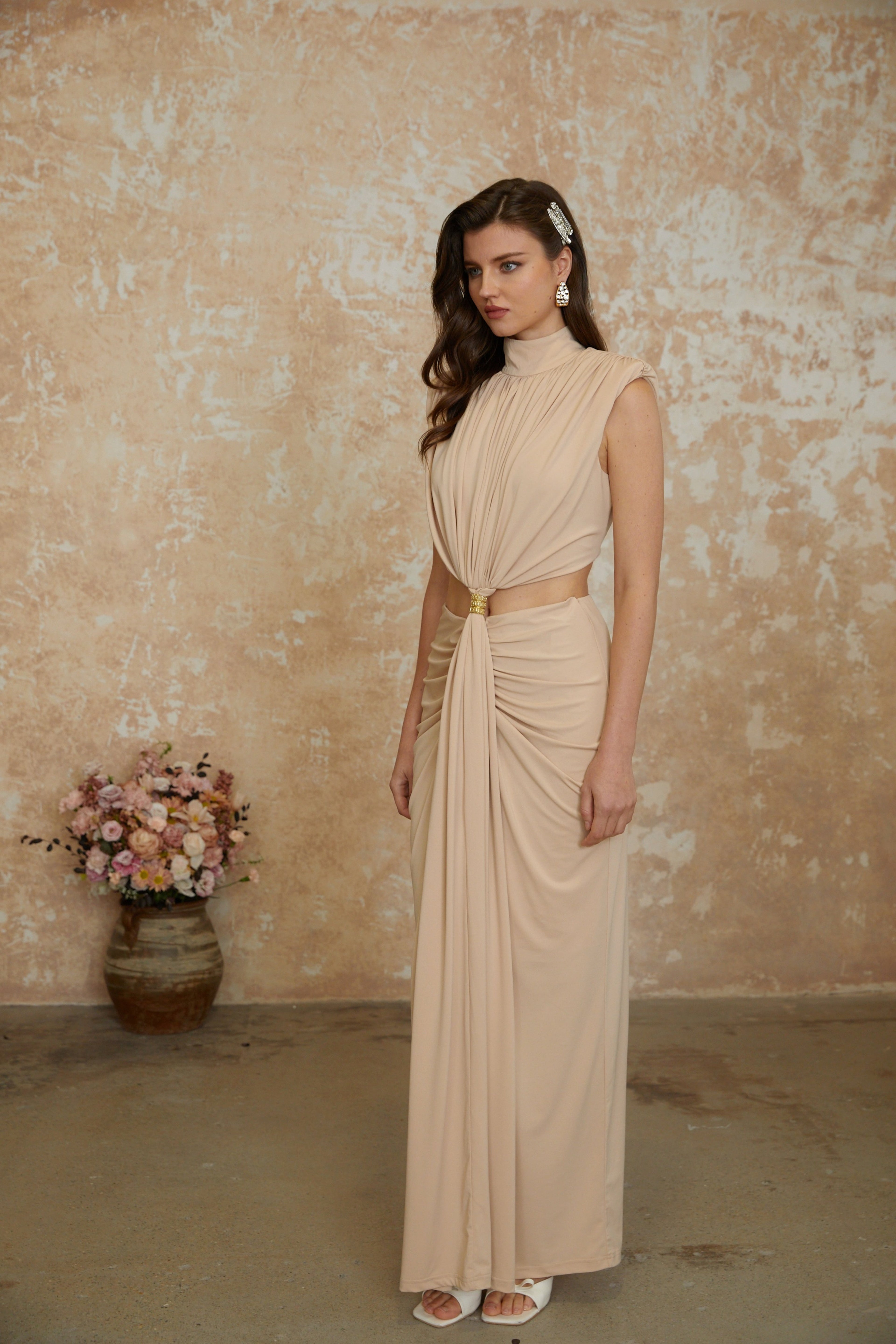 Vestido largo maxi con cuello alto y diseño twist frontal de color neutro de la marca MRNewyork.