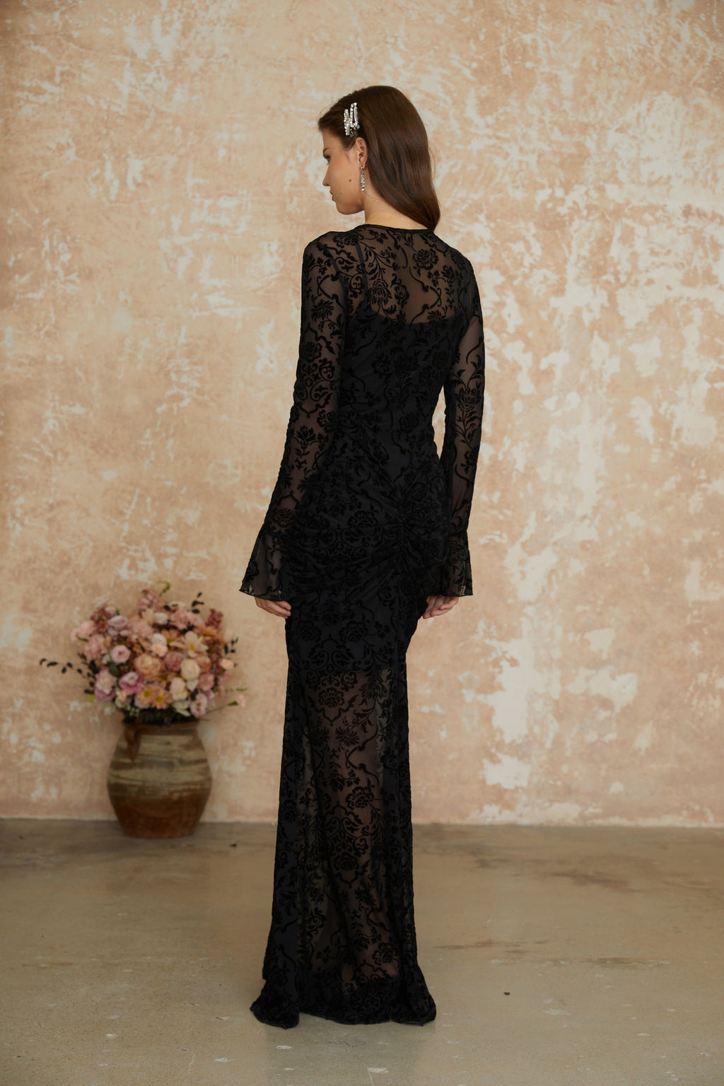 Vestido largo maxi negro con flores en felpa y fruncido, estilo Kismet de MRNewyork, visible en la imagen.