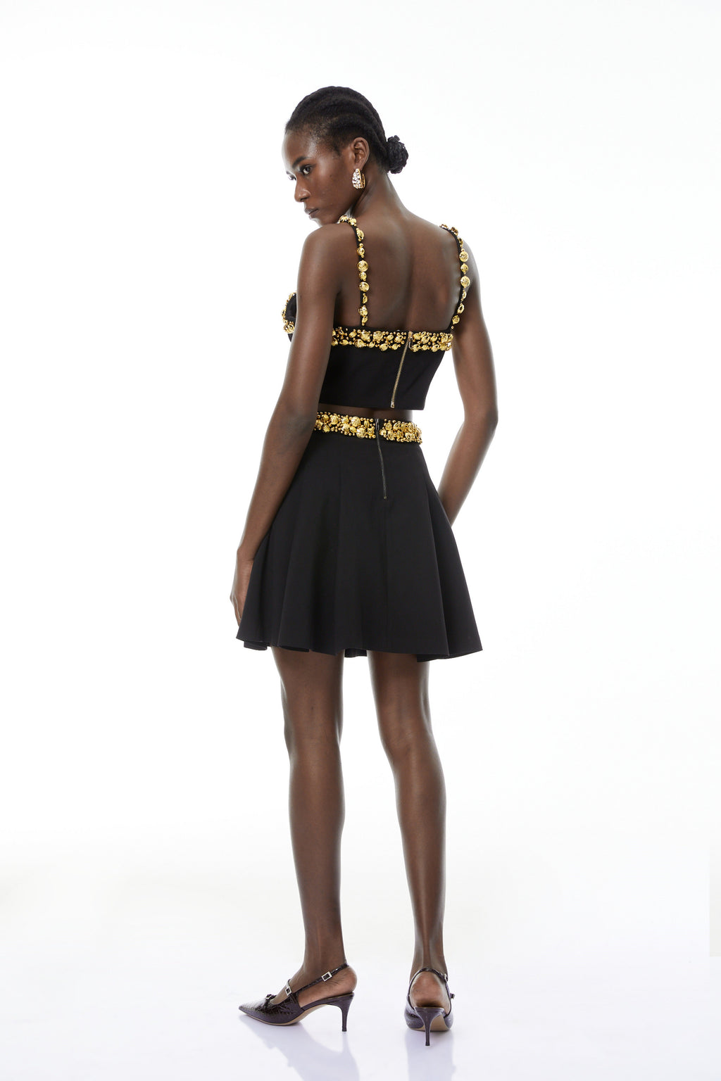 Conjunto de top negro y minifalda con botones de MRTokyo, diseño moderno y elegante en la imagen.