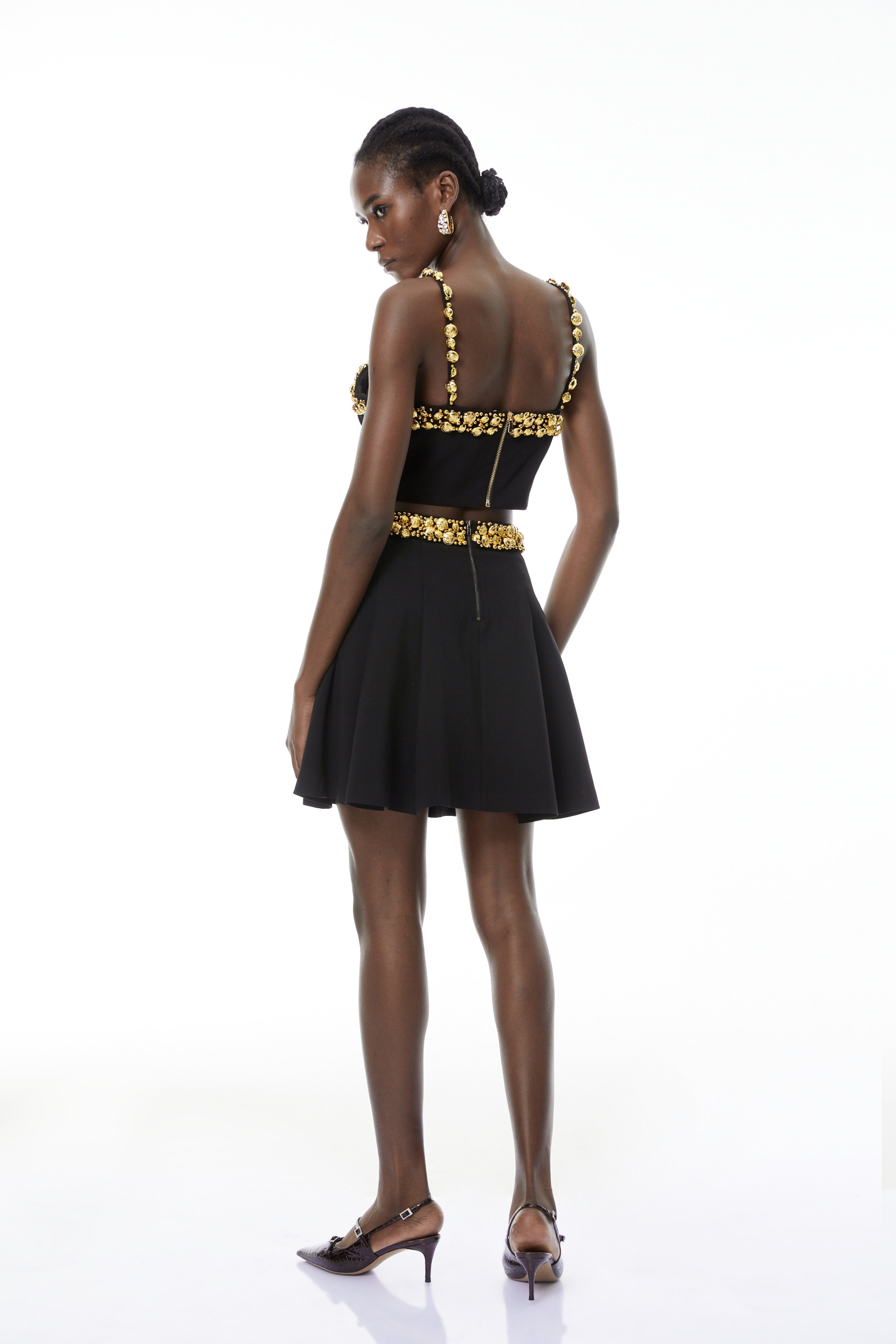 Conjunto de top negro y minifalda con botones de MRTokyo, diseño moderno y elegante en la imagen.