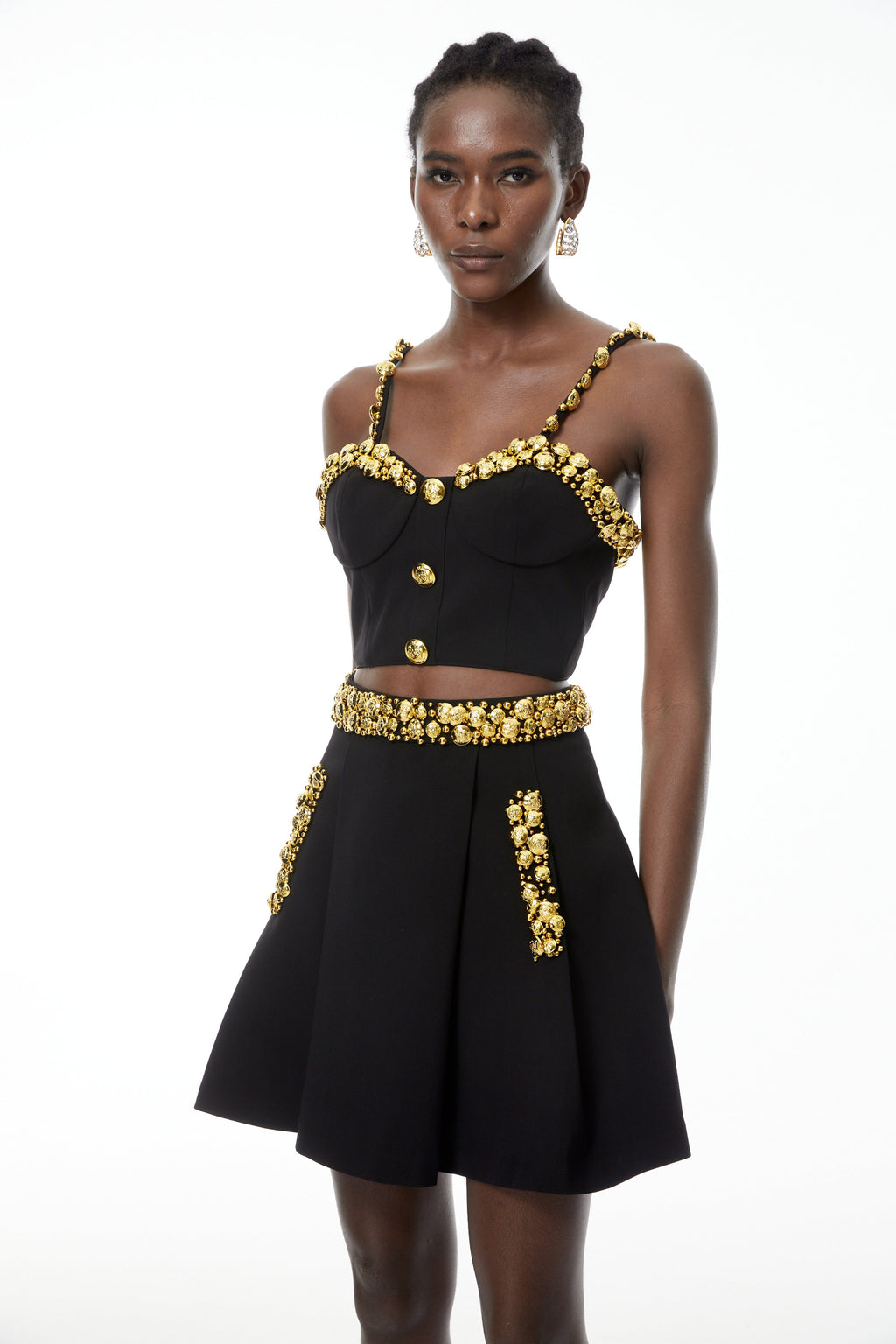 Conjunto de top negro y minifalda con botones de MRTokyo, diseño elegante y moderno, visible en la imagen.