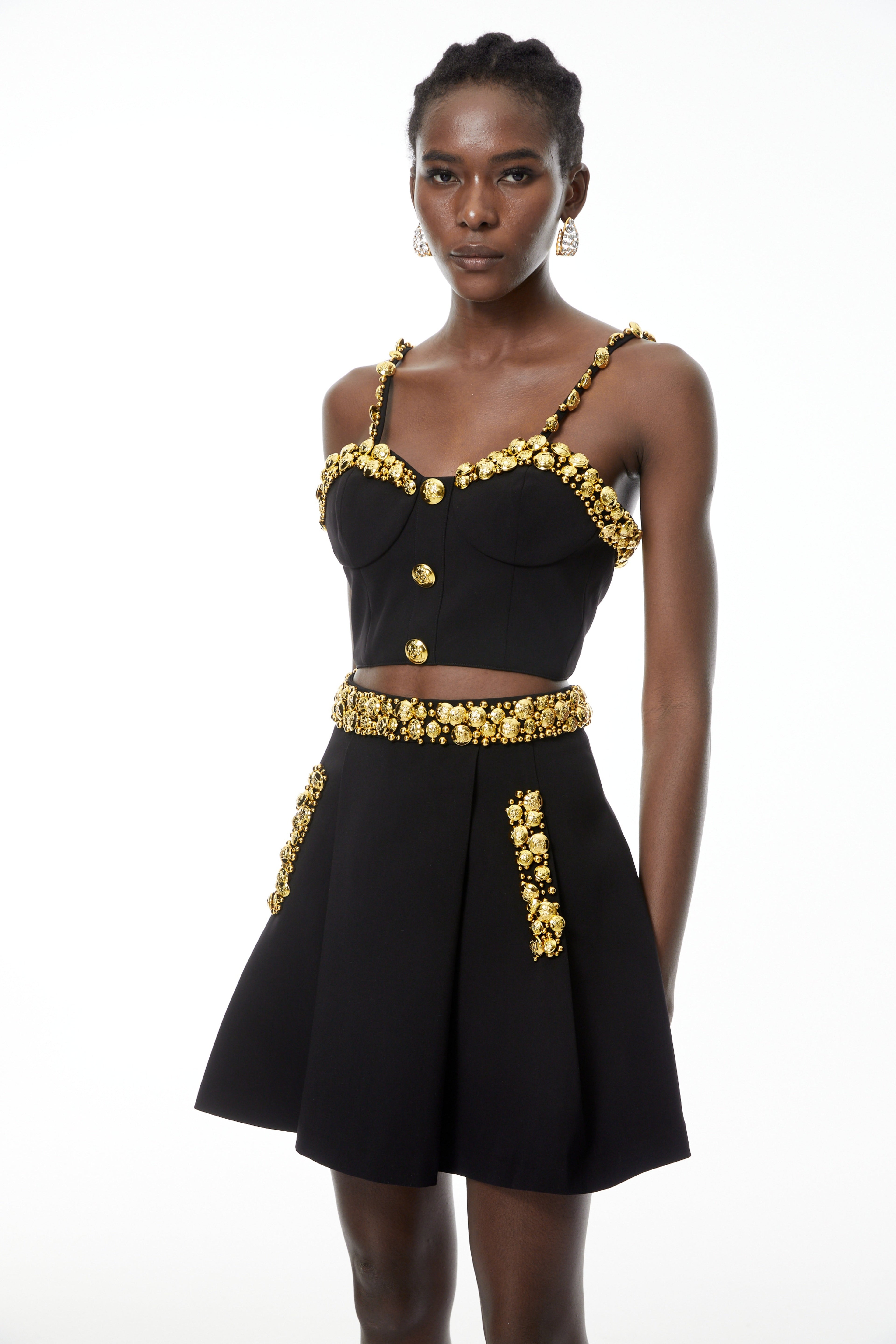 Conjunto de top negro y minifalda con botones de MRTokyo, diseño elegante y moderno, visible en la imagen.