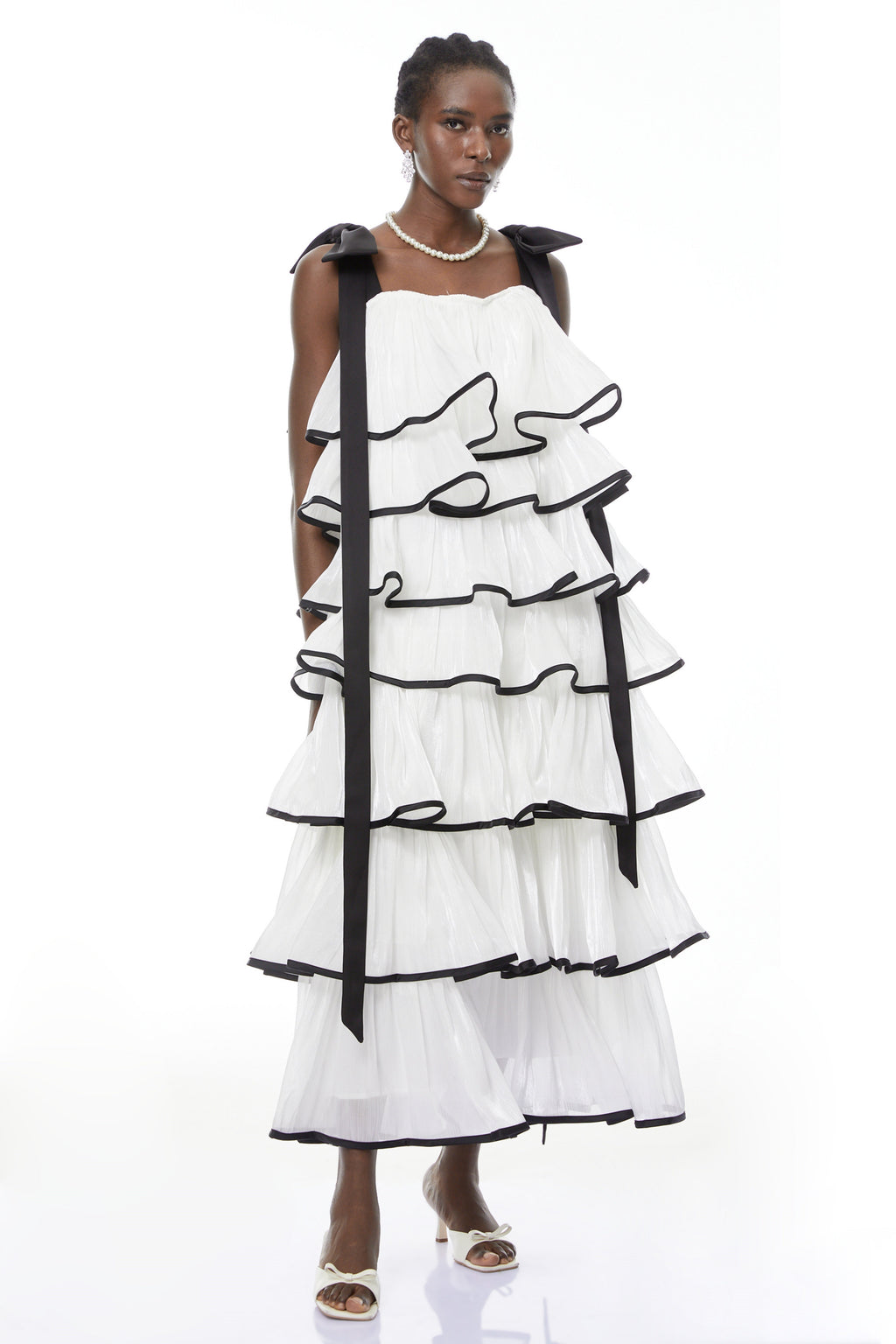 Vestido maxi blanco Larissa de MRMelbourne con volantes y lazos, mostrando su diseño elegante y detalles femeninos.