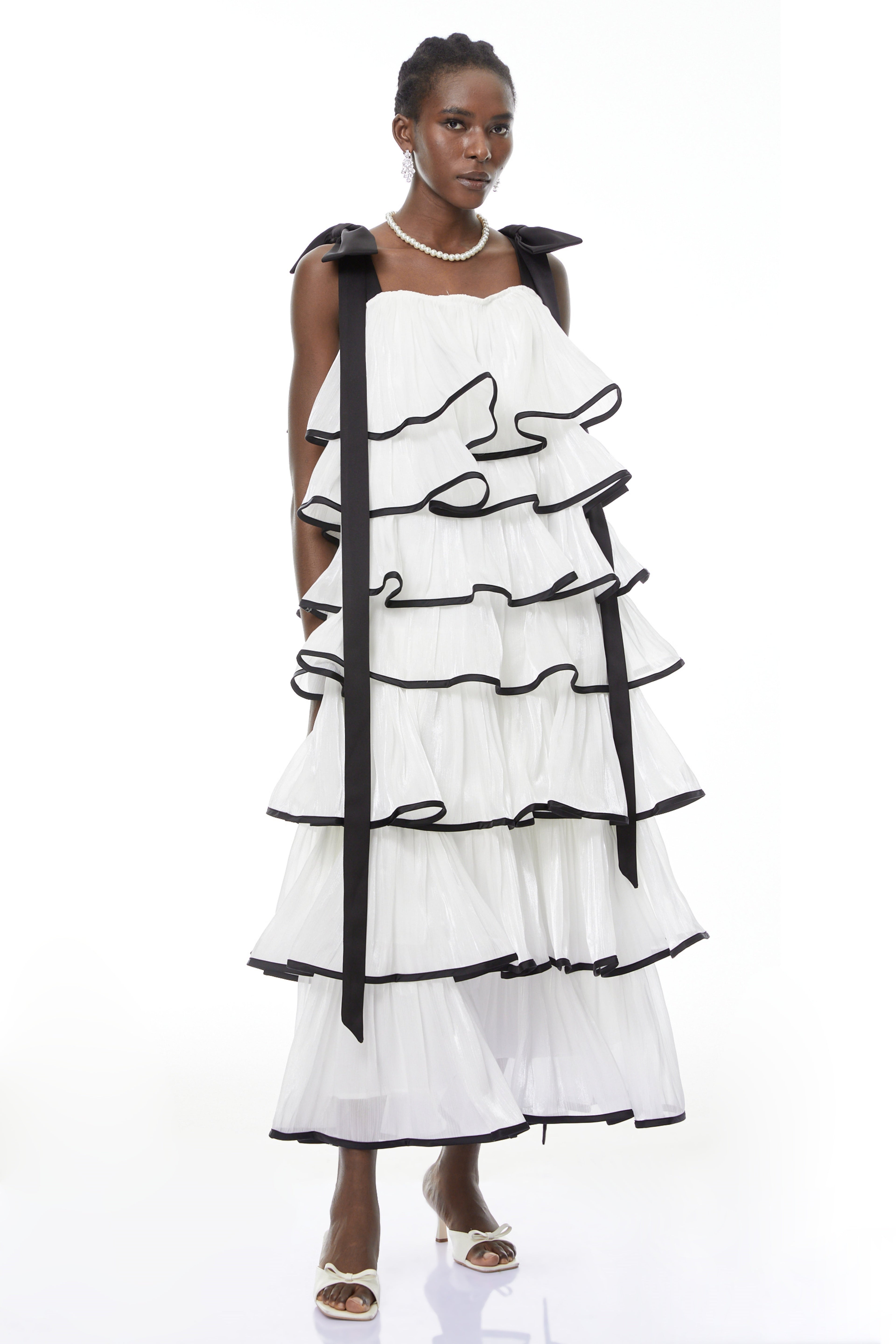 Vestido maxi blanco Larissa de MRMelbourne con volantes y lazos, mostrando su diseño elegante y detalles femeninos.