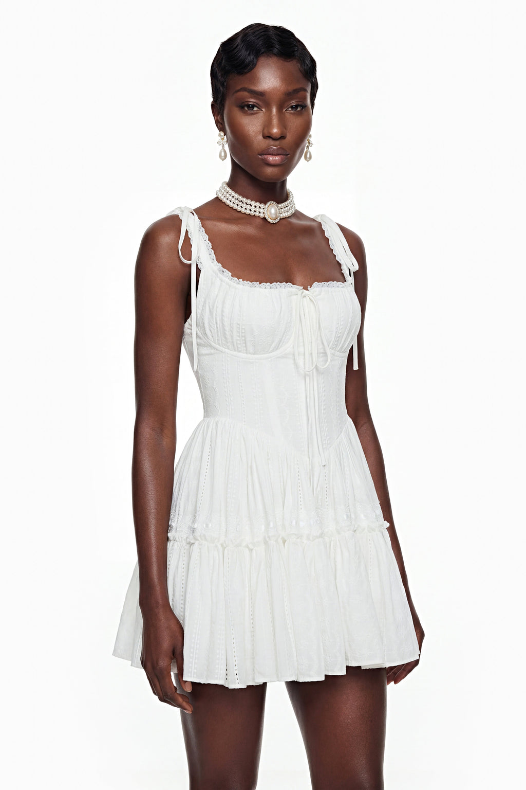 Vestido mini blanco con encaje con volantes de la marca MRMelbourne, muestra el diseño con detalles de encaje y estilo elegante.