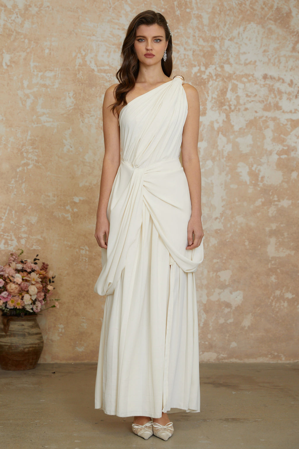 Vestido largo blanco con drapeado, abertura alta y detalles acampanados, diseñado por MRNewyork.
