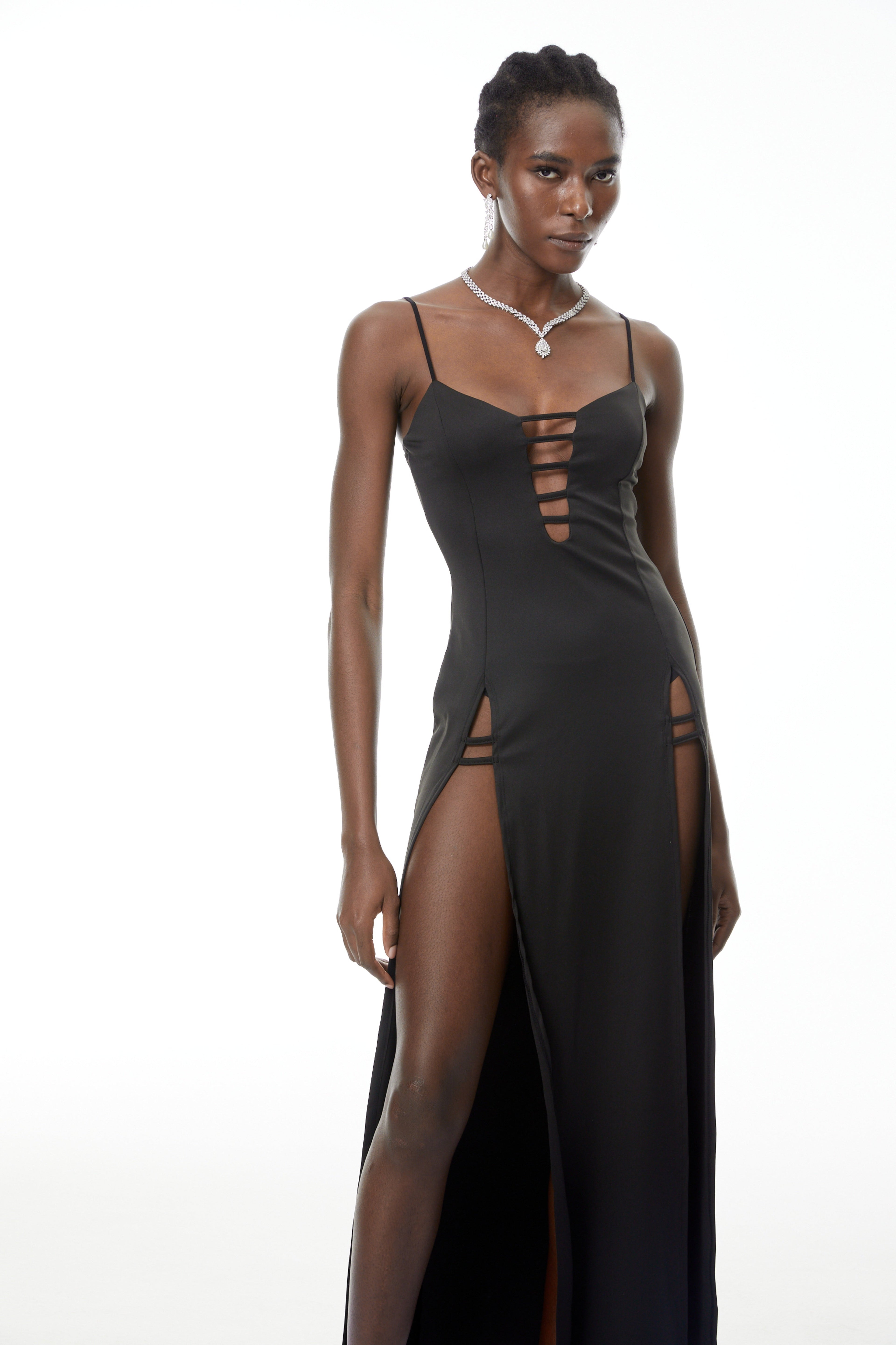 Vestido maxi negro Oona con aberturas y alta abertura de MRTokyo, muestra su diseño elegante y detalles en la tela.