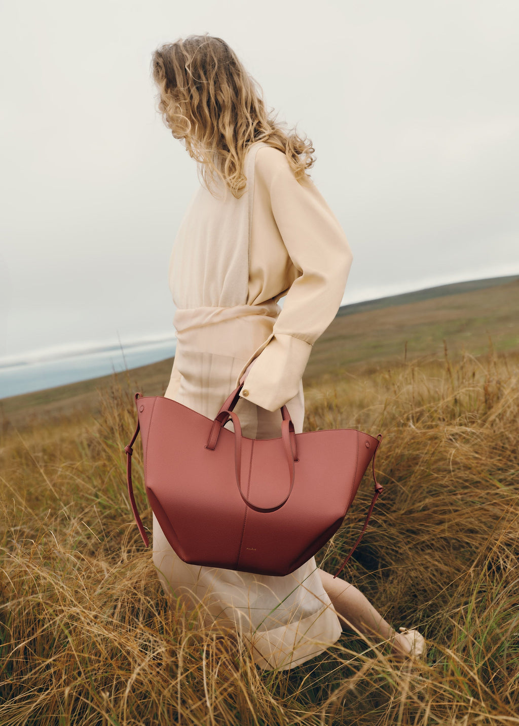 Bolso de mano Polène Cyme en terracota piel granulada, diseño elegante y moderno, con detalles en piel de alta calidad.