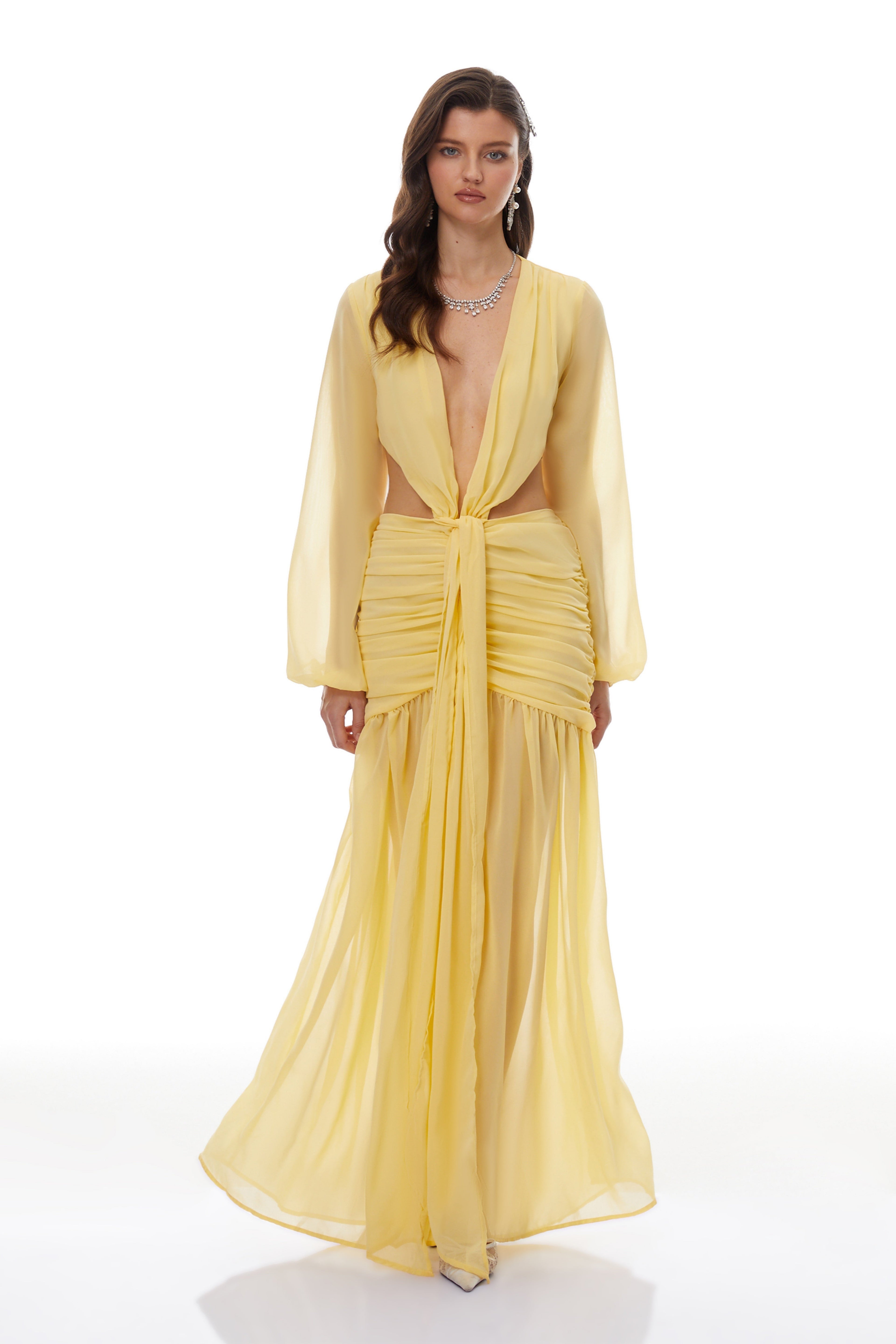 Vestido largo maxi de gasa amarilla con torsión en el diseño, de la marca MRNewyork, muestra la prenda en un fondo neutro.