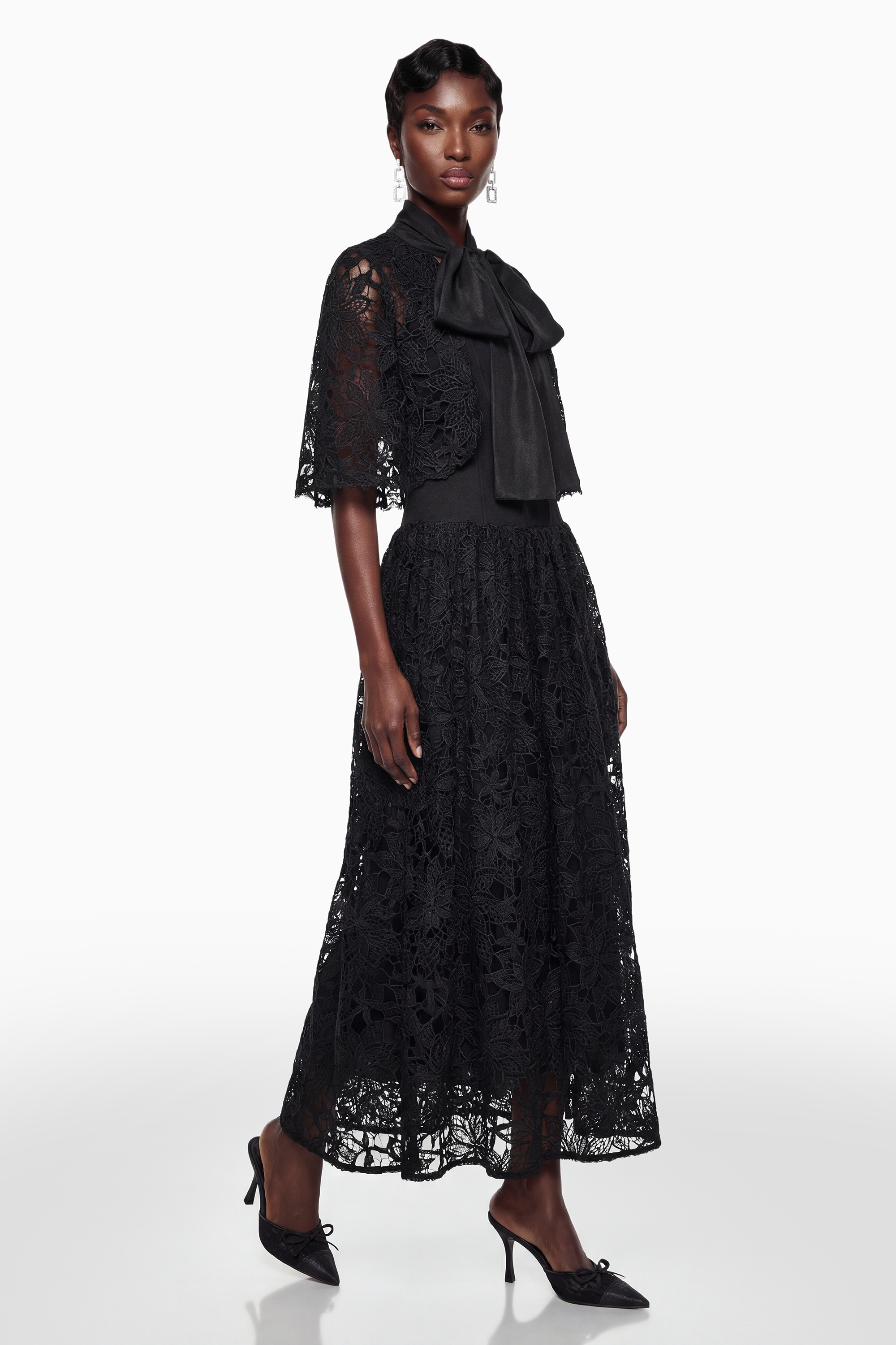 Vestido largo de encaje floral negro de Sissel de MRMelbourne con lazo autoadhesivo, mostrando detalles de encaje y diseño elegante.