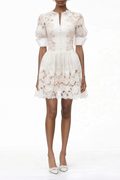Vestido mini blanco con apliques florales y recortes en el centro, de la marca MRMelbourne, muestra los detalles del diseño.