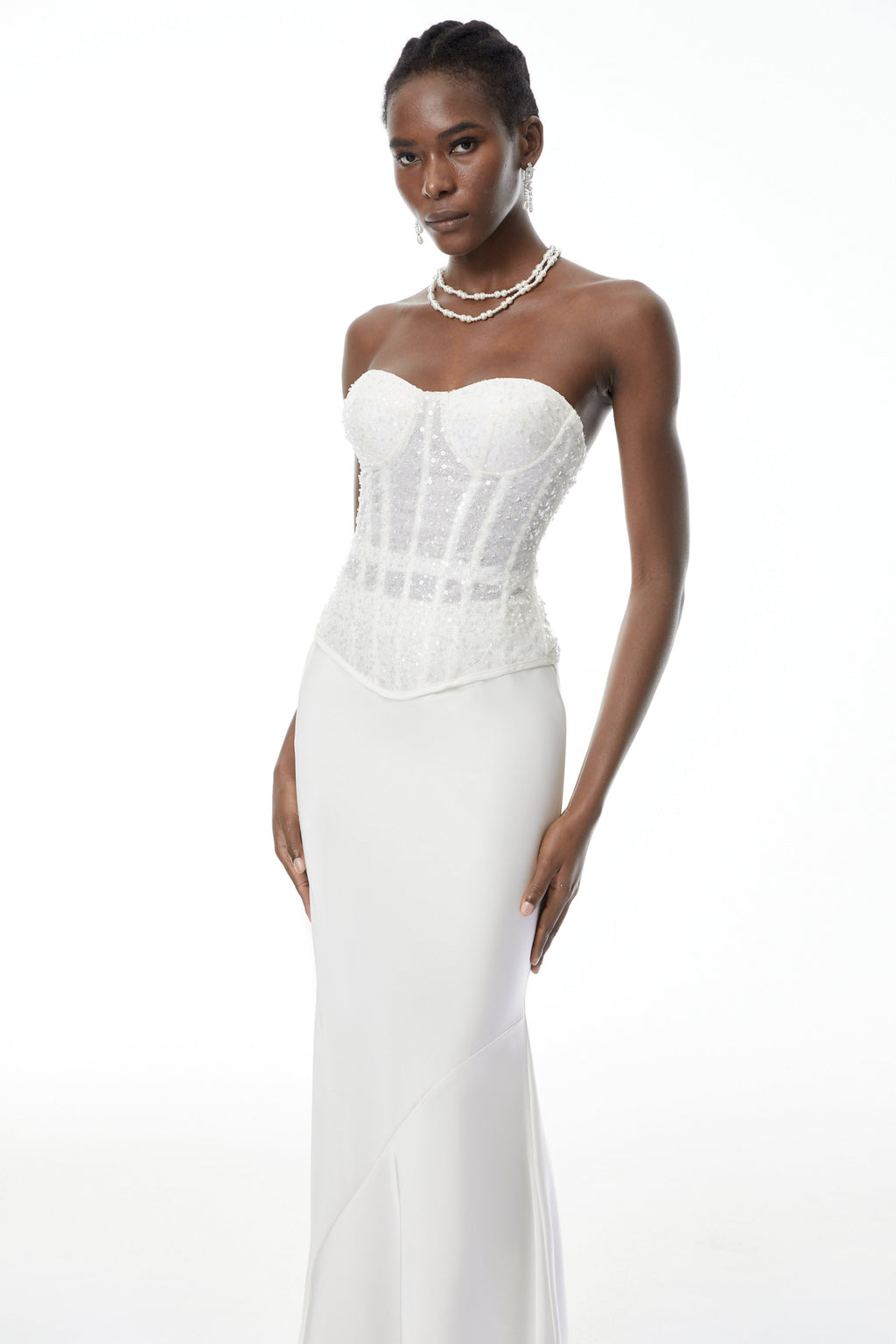 Conjunto de corsé blanco con lentejuelas y falda de satén, de la marca MRTokyo, mostrando un estilo elegante y brillante.