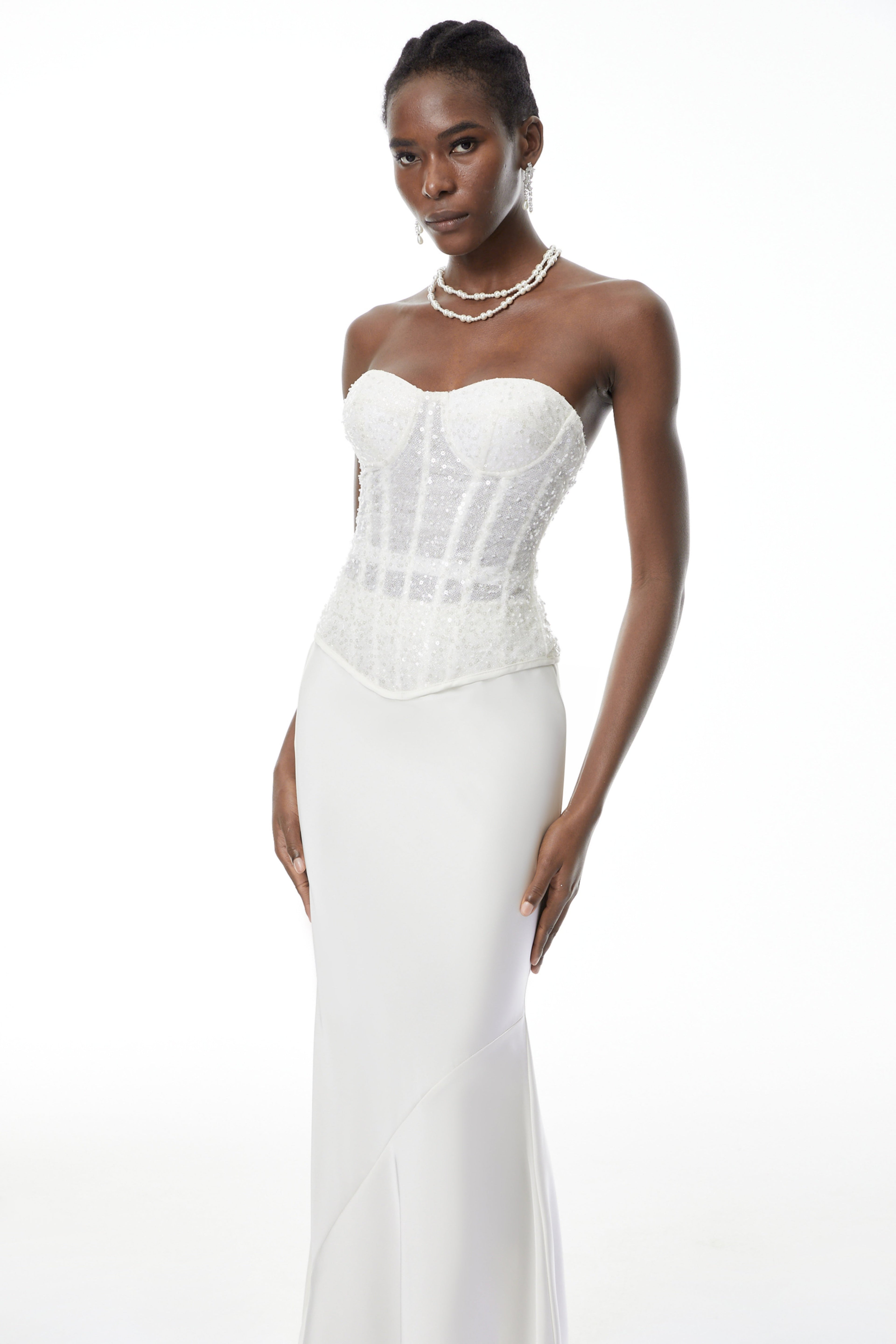 Conjunto de corsé blanco con lentejuelas y falda de satén, de la marca MRTokyo, mostrando un estilo elegante y brillante.