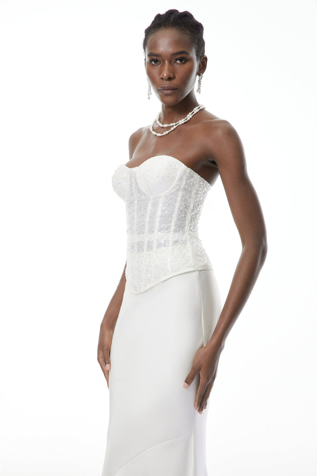 Conjunto de corset blanco con lentejuelas y falda de satén de MRTokyo, visible en conjunto elegante y brillante.