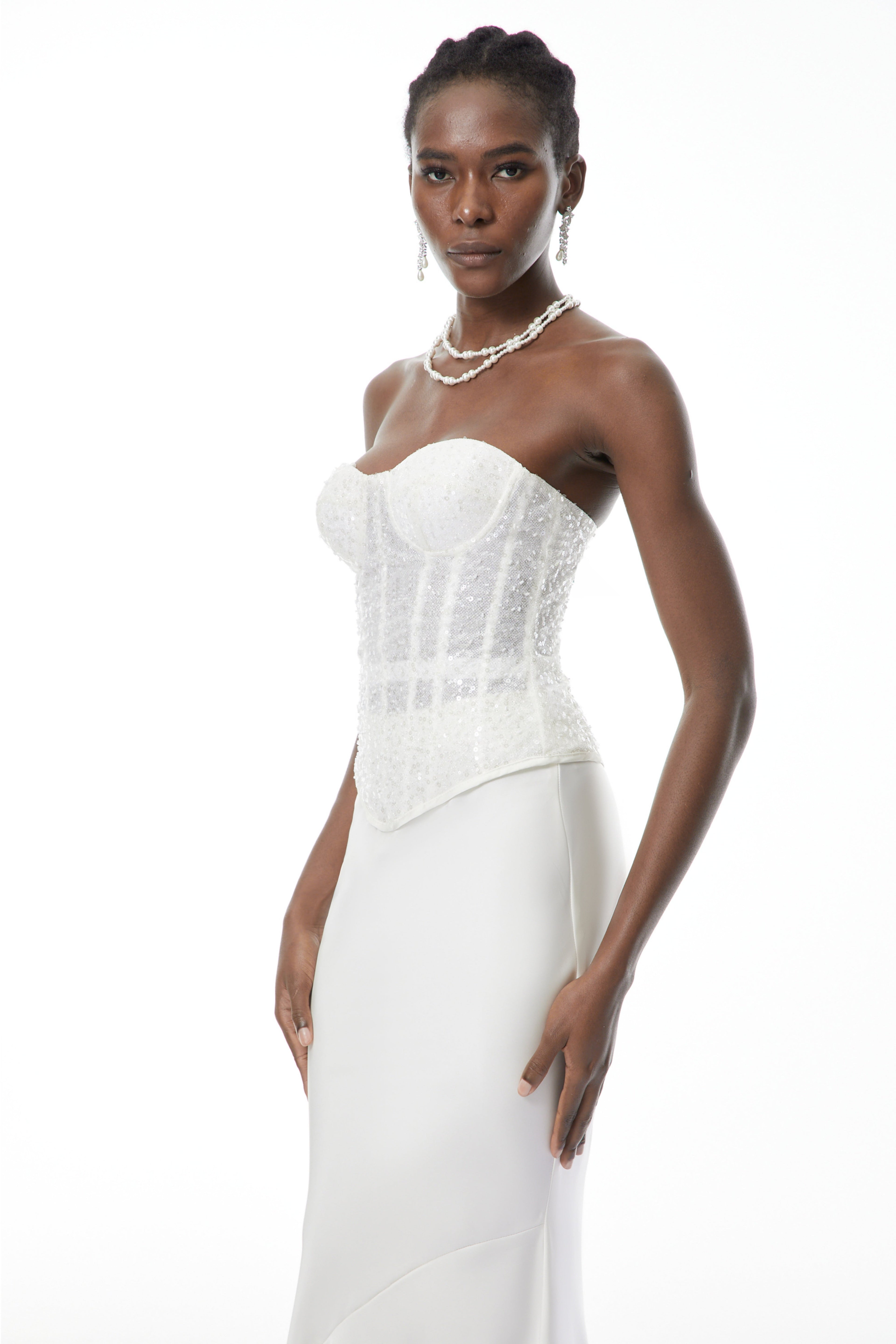 Conjunto de corset blanco con lentejuelas y falda de satén de MRTokyo, visible en conjunto elegante y brillante.