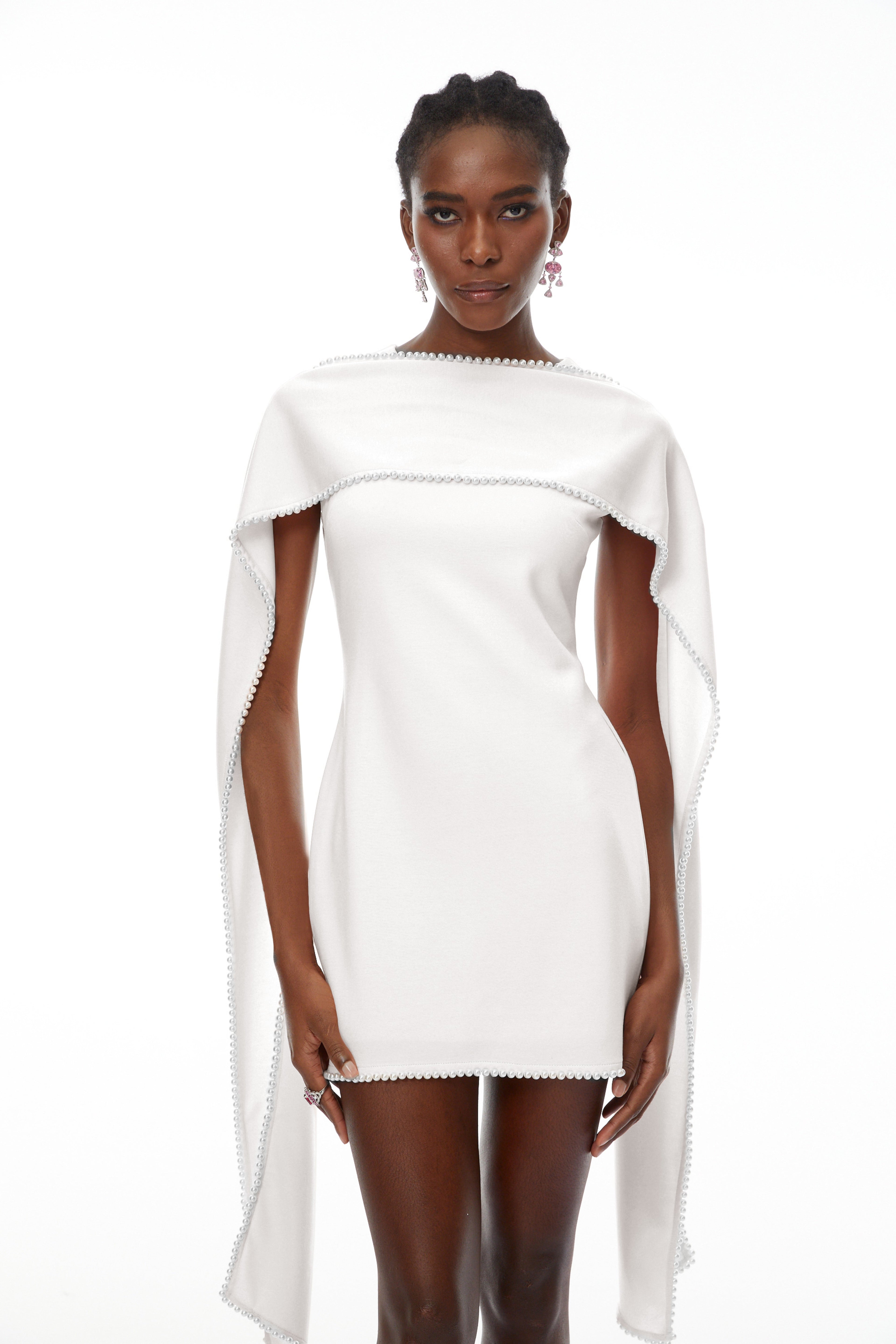 Vestido mini sin mangas blanco Piroska de novia con ribete de perlas, diseño elegante y moderno en la imagen.
