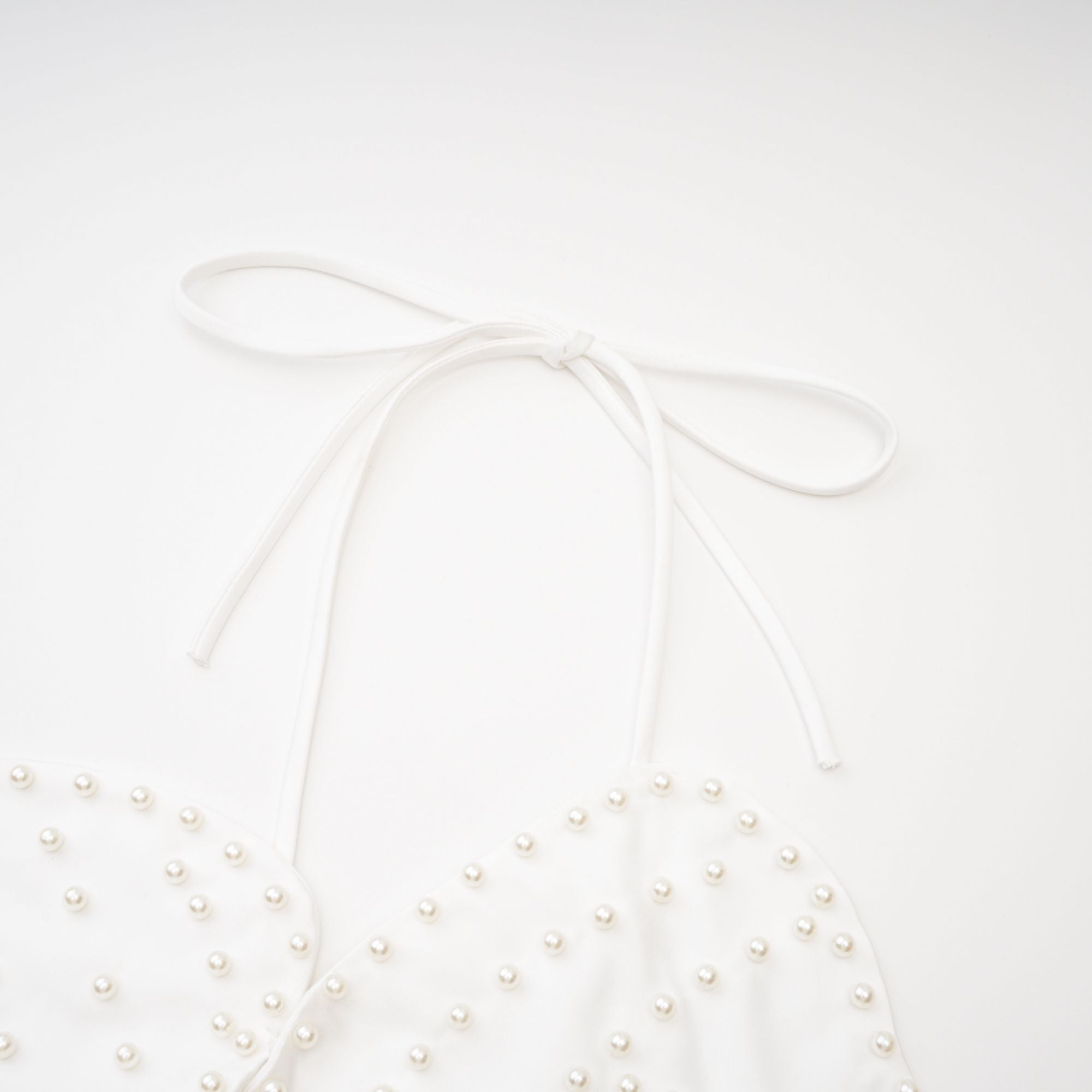 Blusa Maëlle con detalles de perlas falsas y acabado elegante, diseñada por Final Sale, en un estilo moderno y sofisticado.