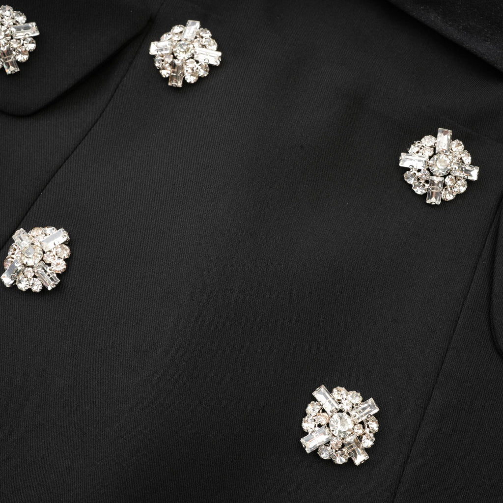 Vestido mini acampanado negro con botones de cristales de la marca Final Sale, con diseño elegante y ajustado en la parte superior.