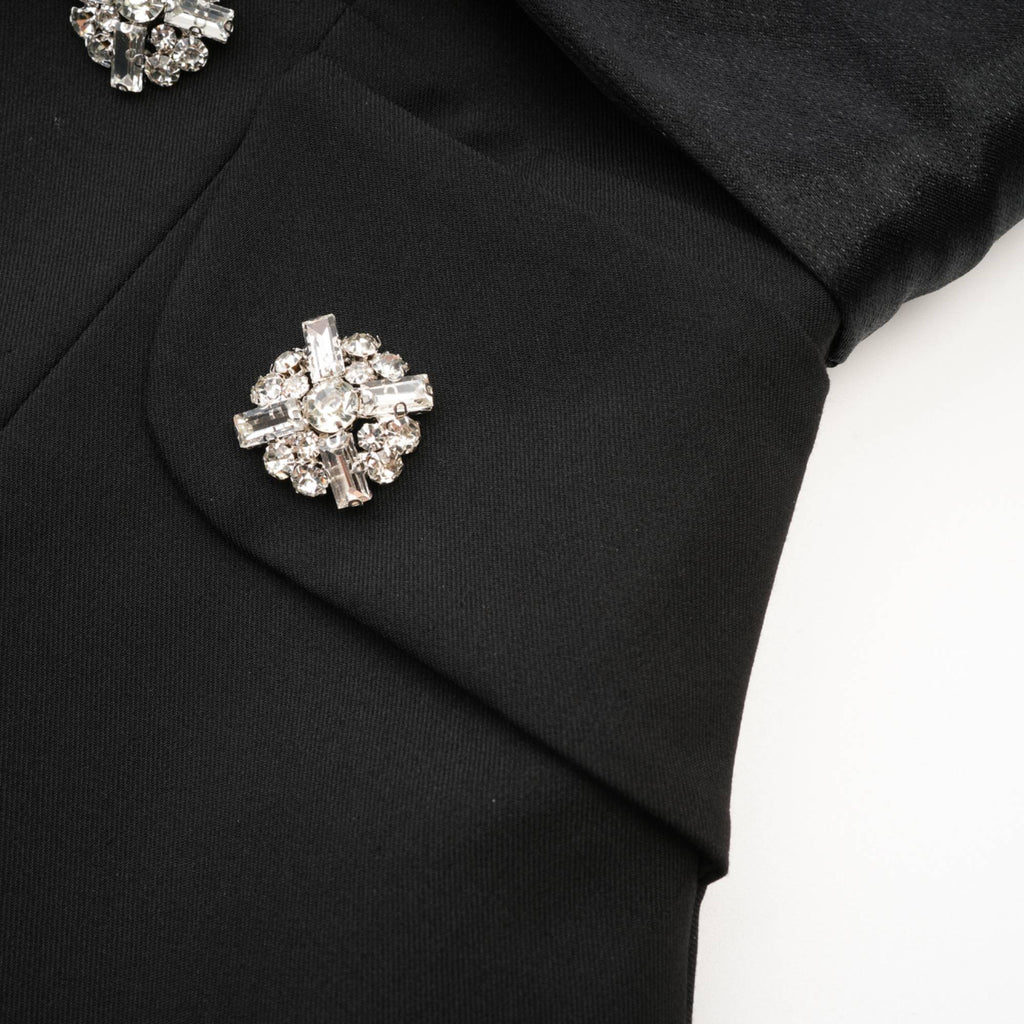 Vestido mini de vuelo negro con botones de cristal de la marca Final Sale, con diseño ajustado en la parte superior.